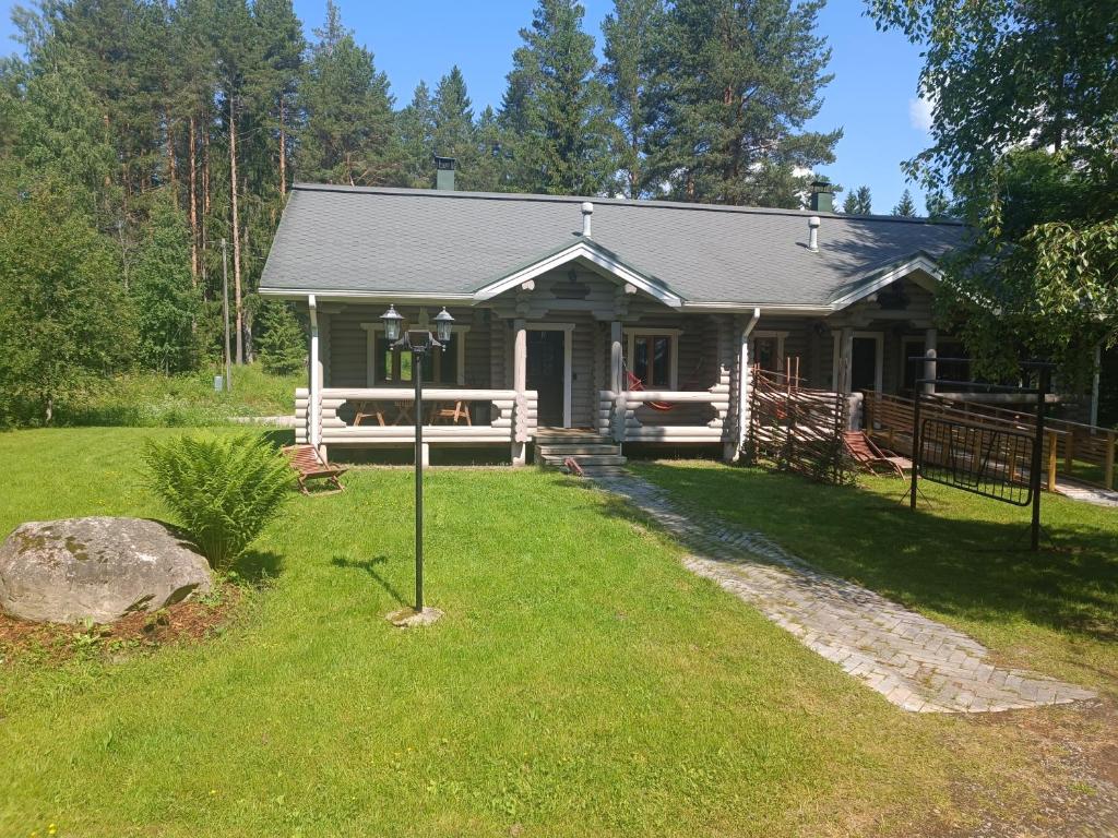 a log cabin with a porch and a yard at Kolilla oy, Purnutar B in Kolinkylä