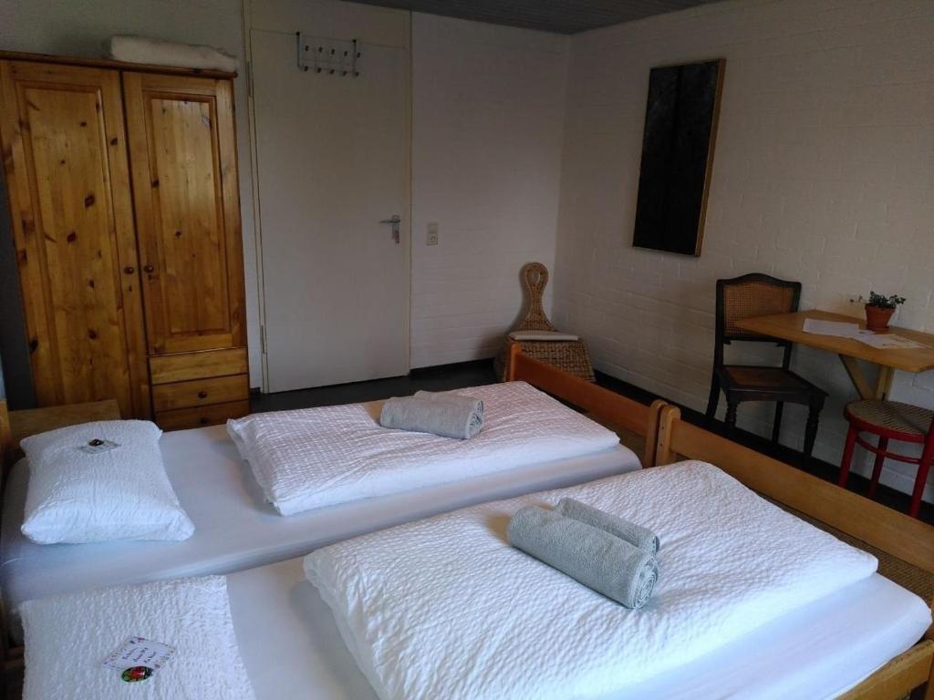 two twin beds in a room with a table at Zimmer 12 in Gomadingen