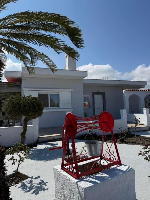a red chair sitting in front of a house at Anastasia's House Kos in Marmaroto