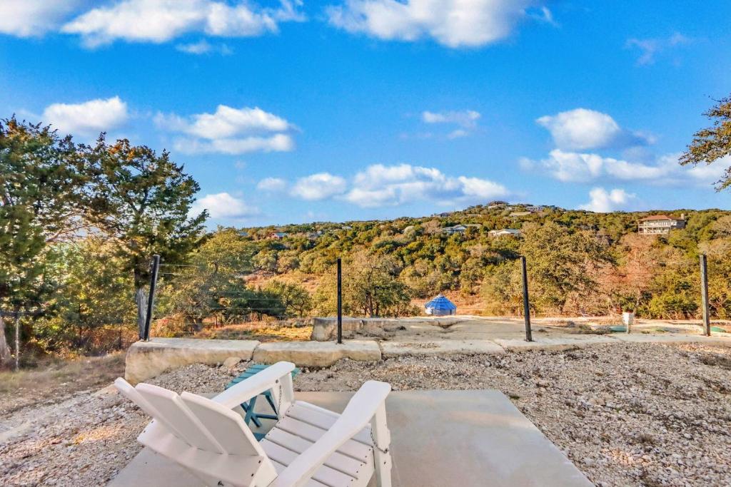 two white chairs sitting on a patio with a mountain at The Container Retreat - C12.. in Canyon Lake