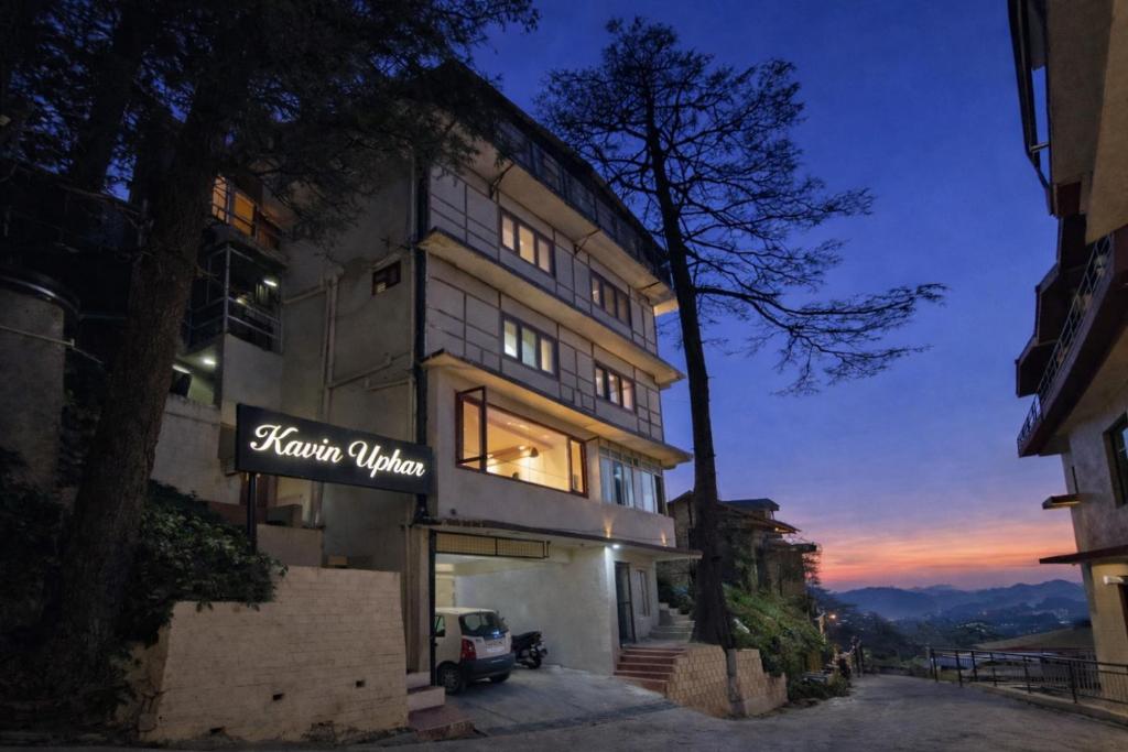 a building with a sign on the side of it at Kavin Uphar The Mall Road in Shimla