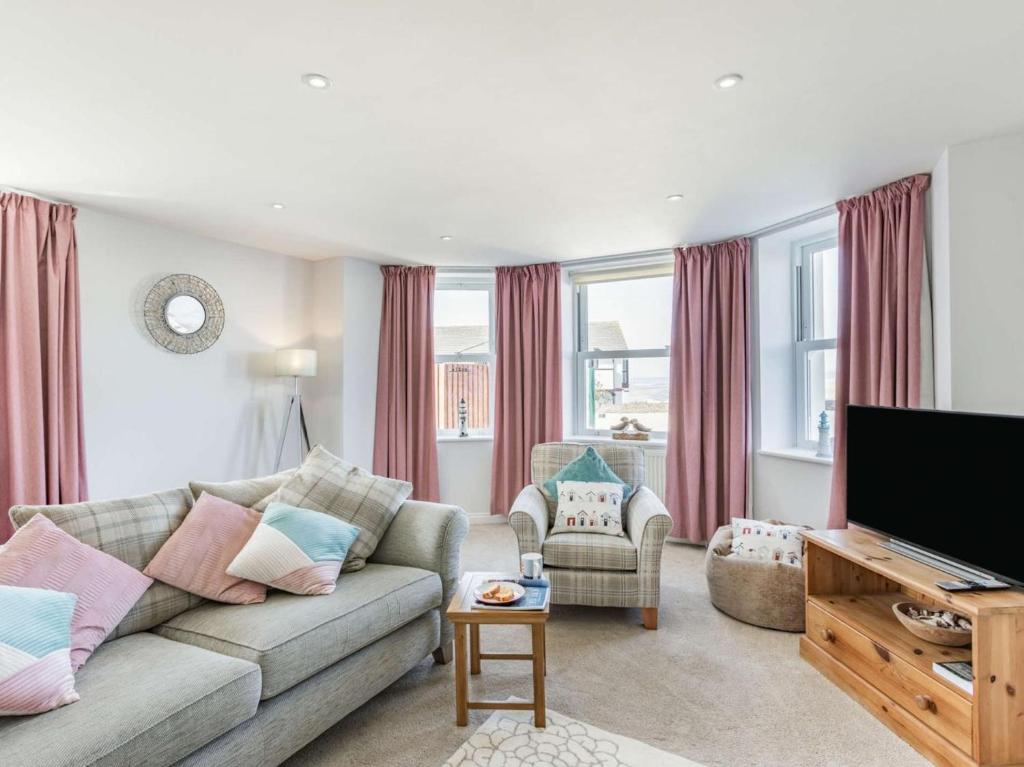 a living room with a couch and a flat screen tv at 2 Bed in Bideford oc-73895 in Westward Ho