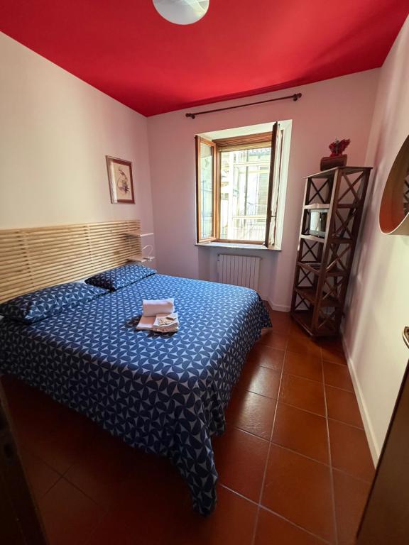 a bedroom with a blue bed and a window at COZY Place 26 con PARCHEGGIO PRIVATO GRATUITO in Vercelli