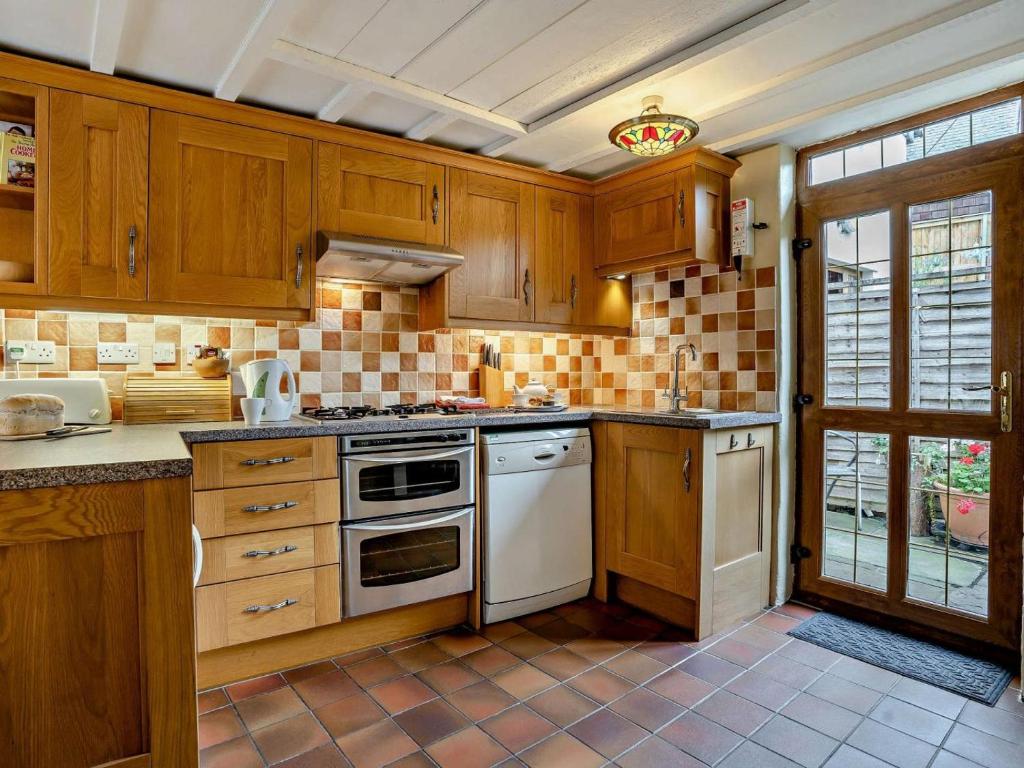 a kitchen with wooden cabinets and white appliances at 1 Bed in Brecon oc-bn367 in Bwlch