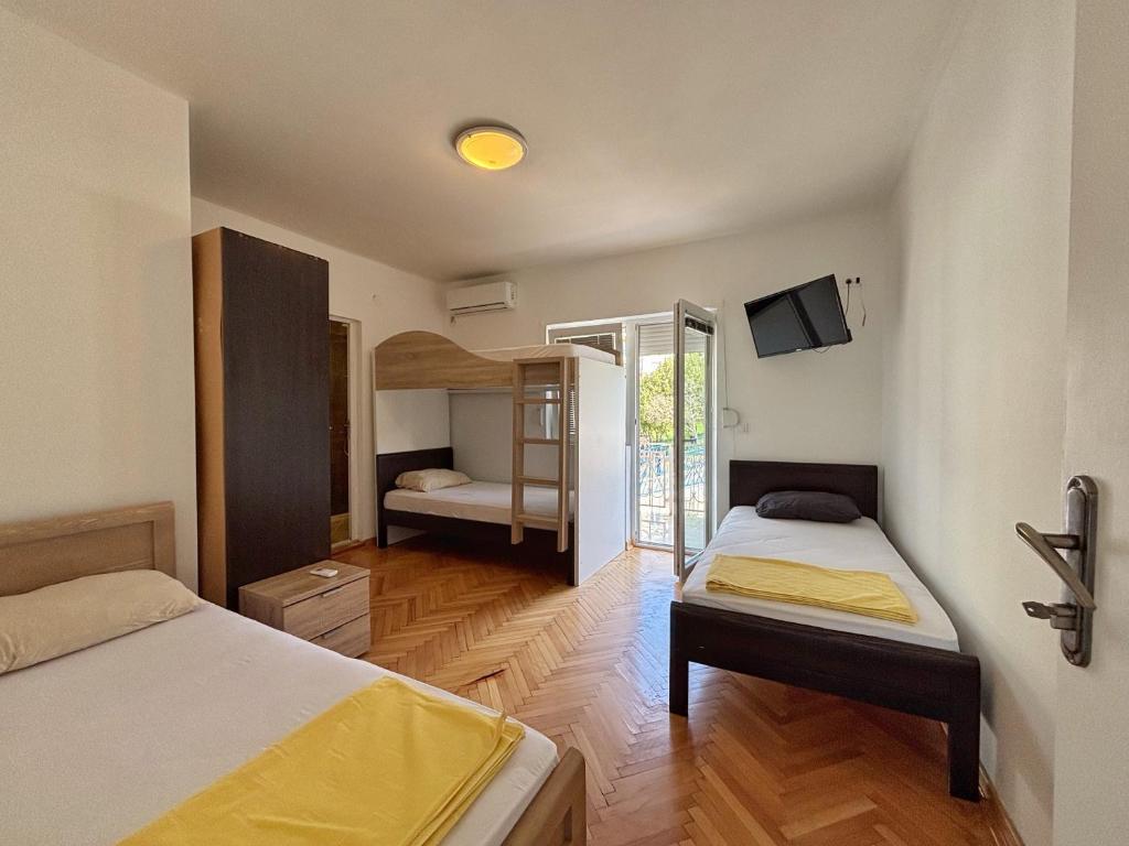 a room with two beds and a television in it at Vega's in Tivat