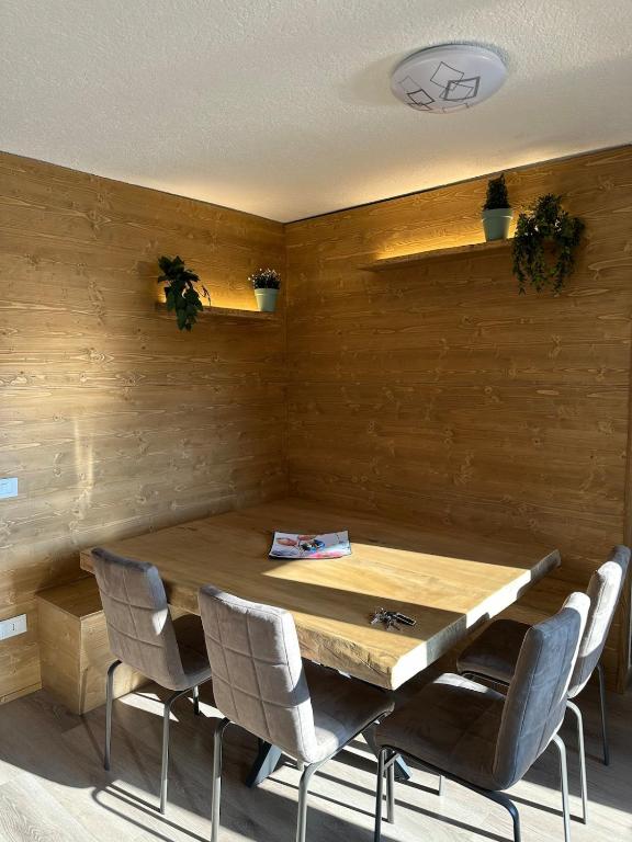 a dining room with a wooden table and chairs at Piazzetta Montecampione in Pian Camuno