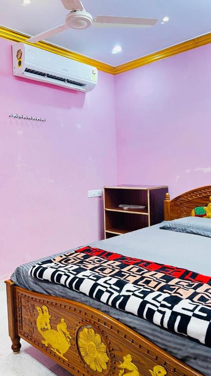 a bedroom with a bed with avertisementatronatronatronstrationstrationstration at Sri Seshadri Rest House in Avanigadda