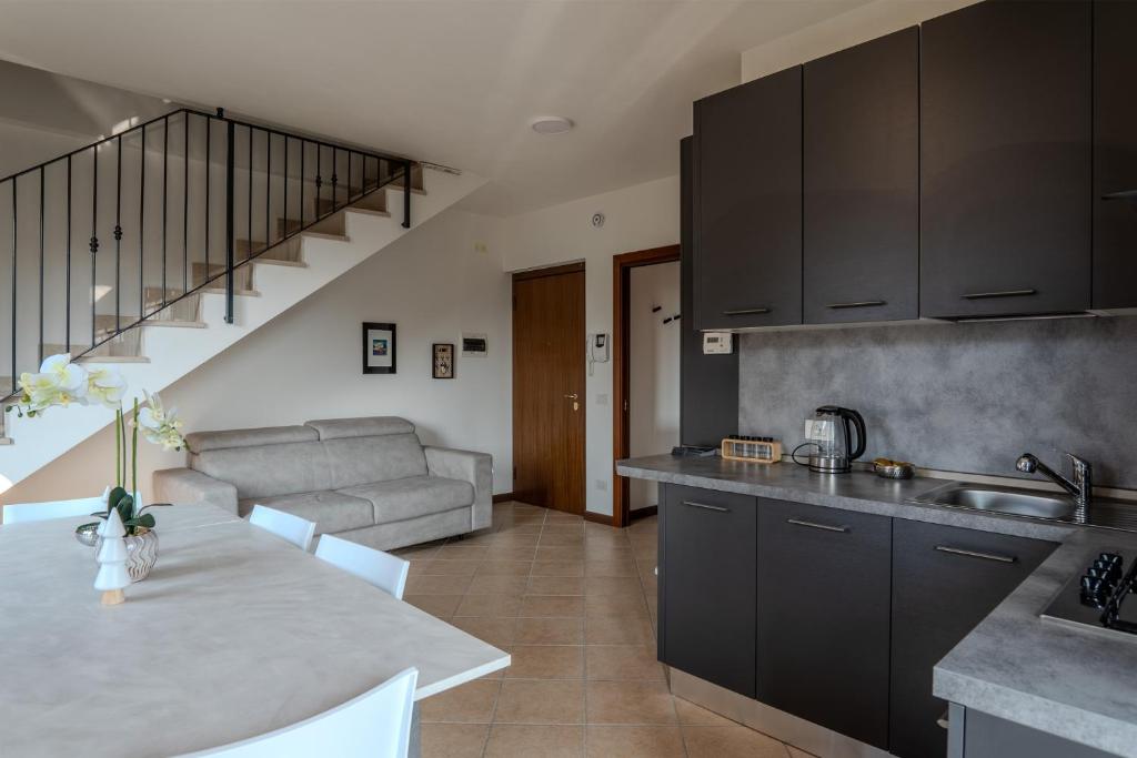 a kitchen with black cabinets and a living room at Relais Terre Divino 2 in Ponton