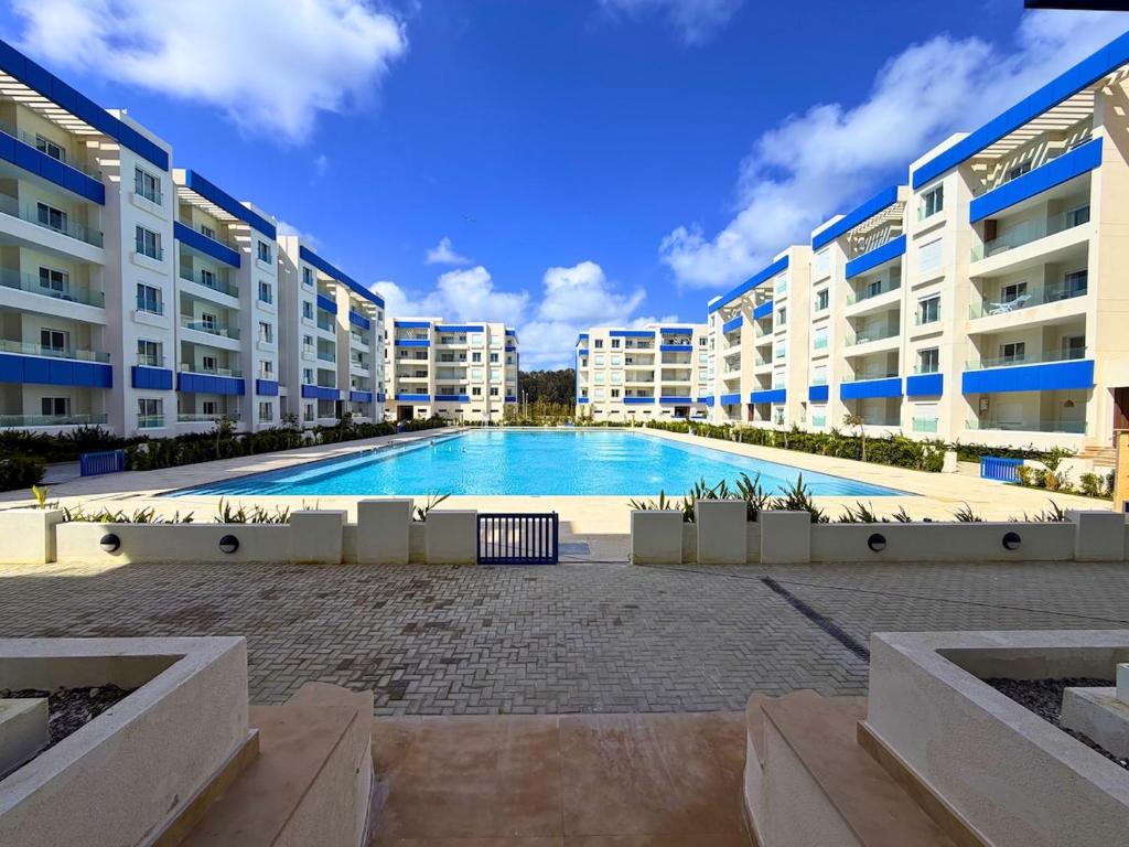 a large swimming pool in the middle of a building at Les Jardins Bleus Pool - Martil in Martil