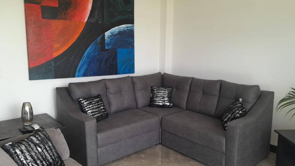 a gray couch in a living room with a painting at Ocean View House, Modern, Elegant with Pool in Coco