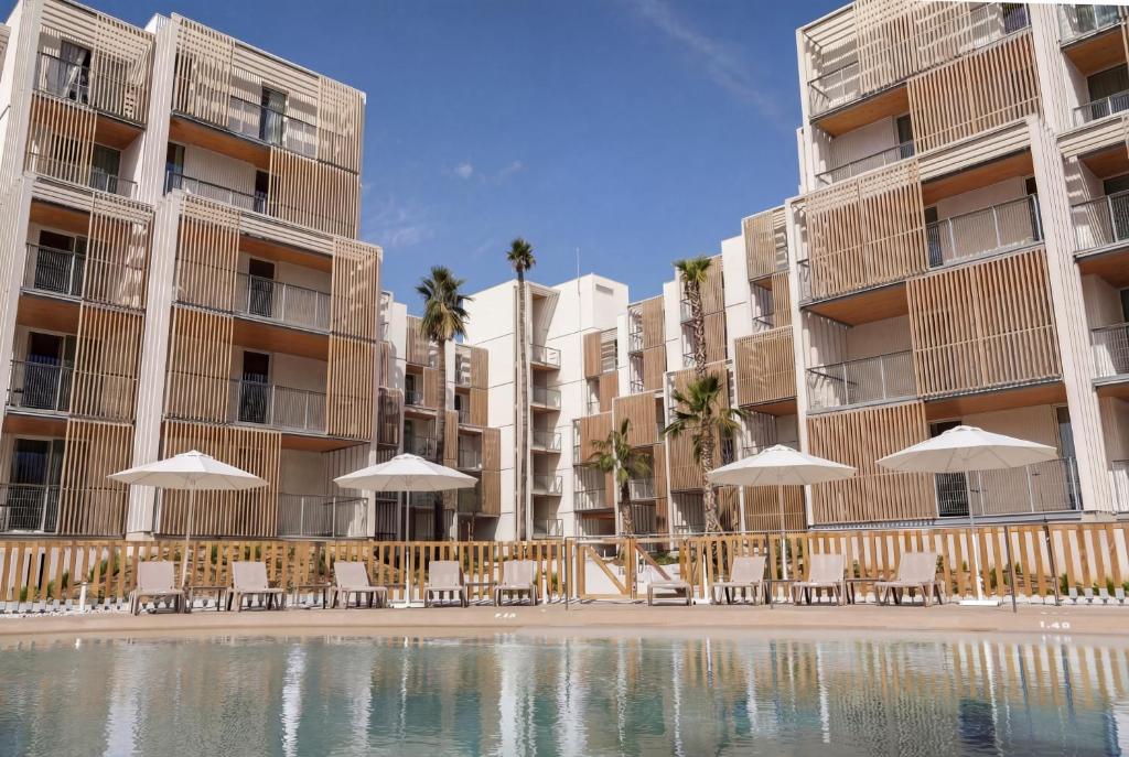 a resort with a pool and chairs and umbrellas at Kora Olea in Torremolinos