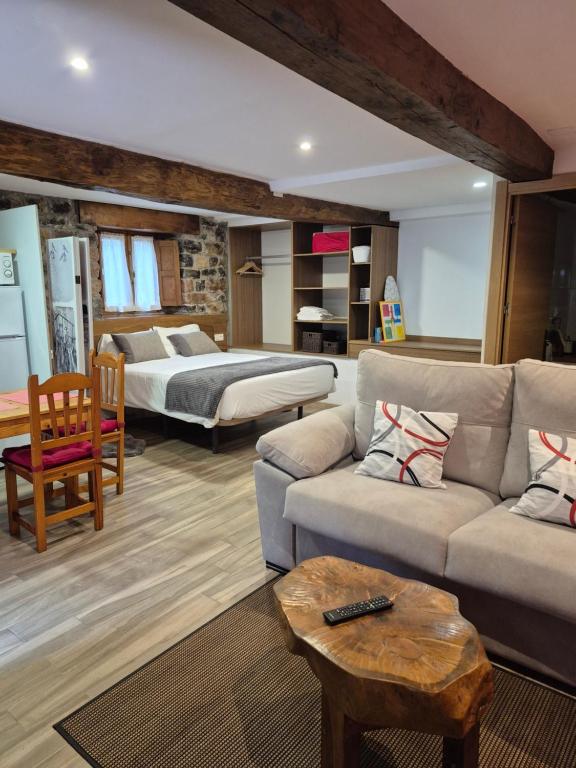 a living room with a couch and a bed at Loft Miradas al Sella in Corigos