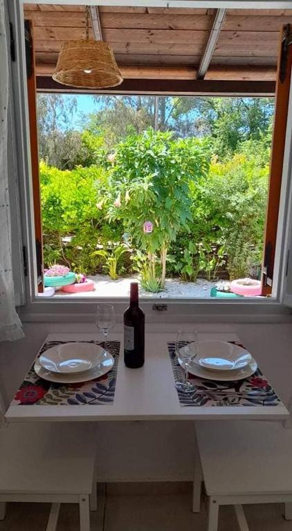 a table with two plates and a bottle of wine at Maria's House Kontokali in Kontokali