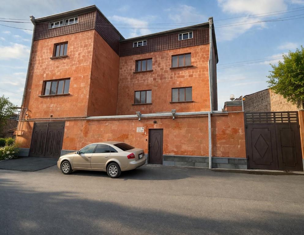 a car parked in front of a brick building at Red House in Kʼasakh