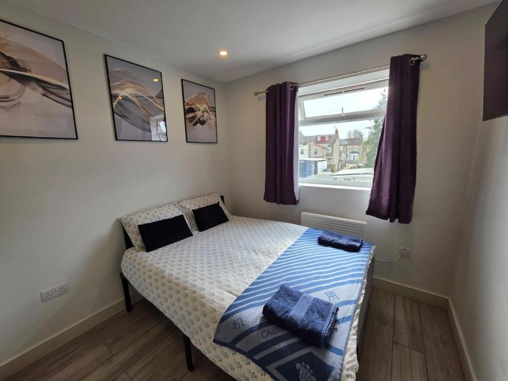 a small bedroom with a bed and a window at Brigstock 4 in Thornton Heath