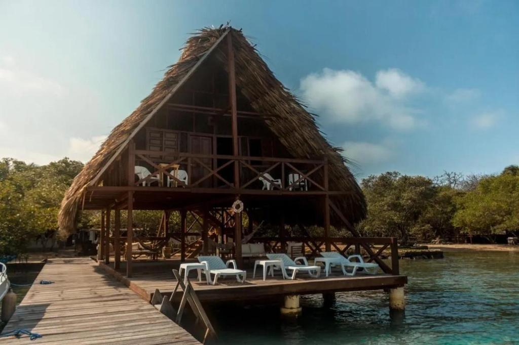 a hut on a dock with chairs on the water at Casa bela in Cartagena de Indias