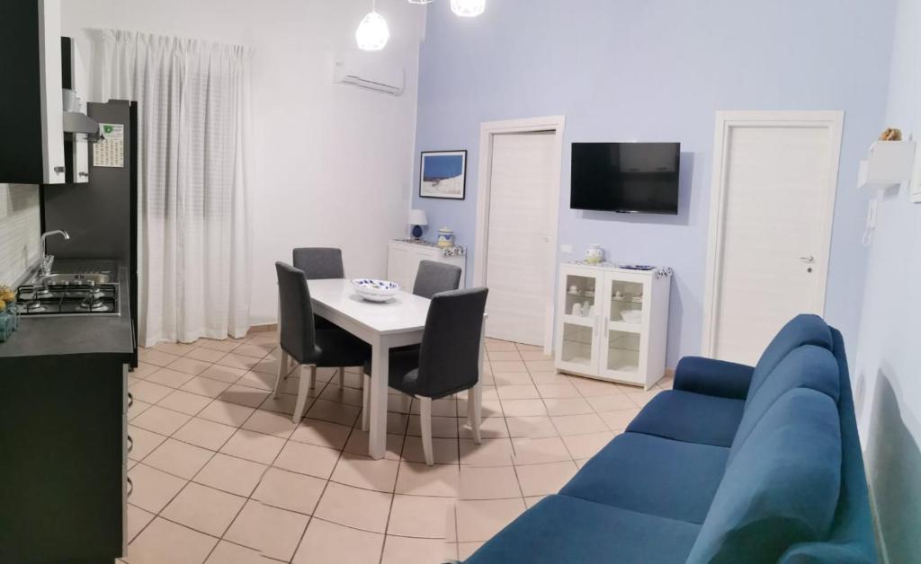 ein Wohnzimmer mit einem blauen Sofa und einem Tisch in der Unterkunft Civico56 in Patti