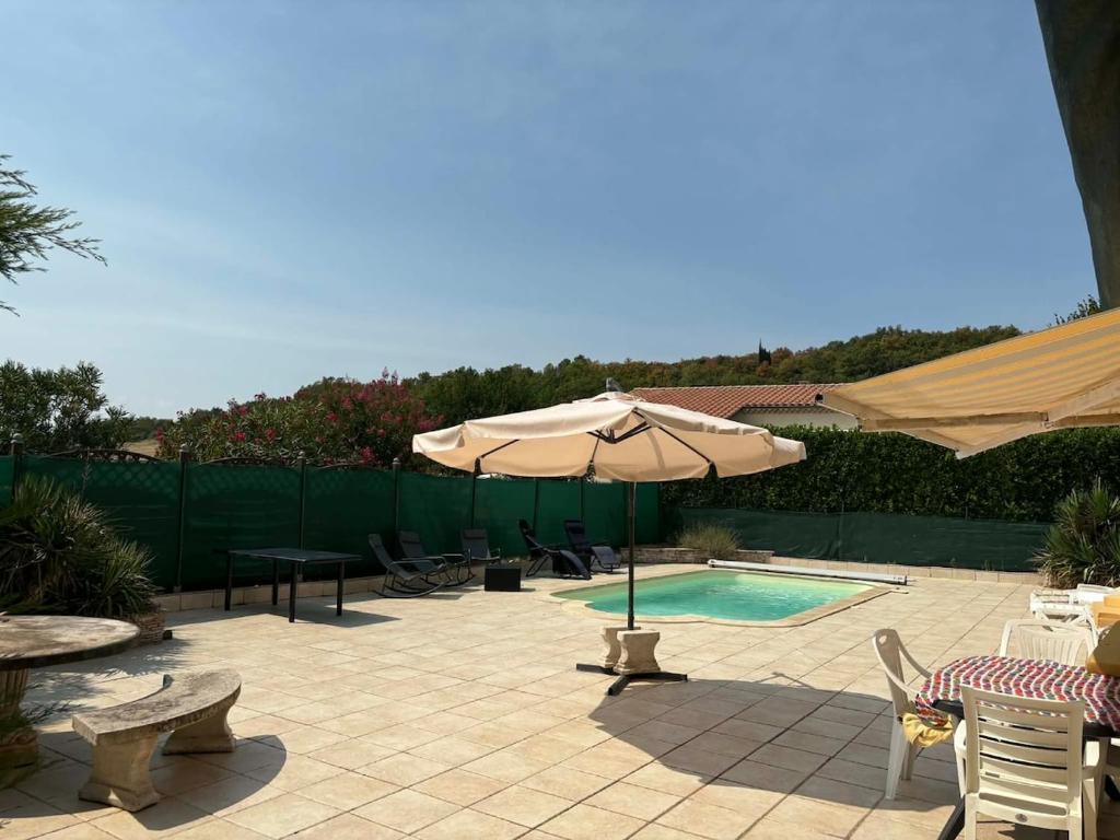 a patio with an umbrella and a swimming pool at Vacation Home in Drôme in Charols