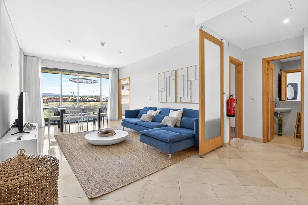 a living room with a blue couch and a table at Aquamar Pro 402 in Quarteira