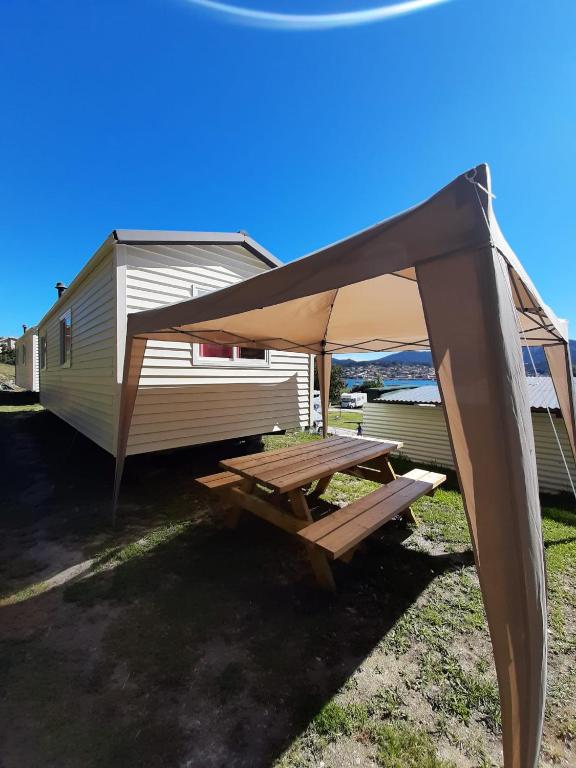 a picnic table under a tent next to a trailer at CCA area in Hio