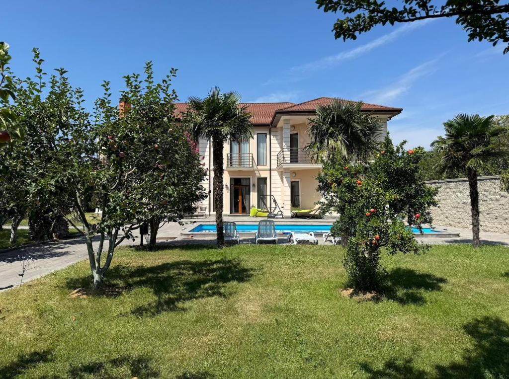 a house with a swimming pool and two trees at Aisi Villa in Misakʼtsʼieli