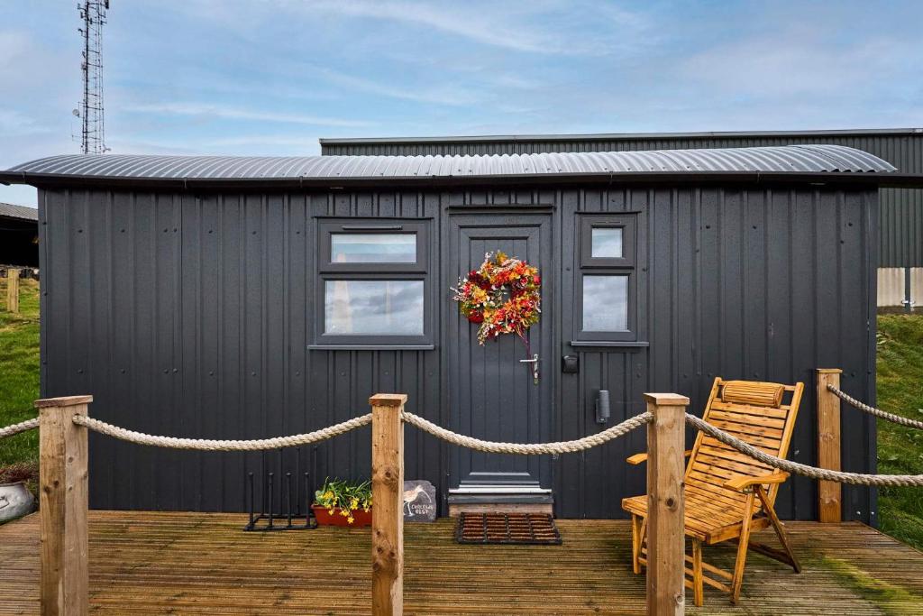 a black shed with a wreath on a deck at Host & Stay - Curlews Rest in Longridge