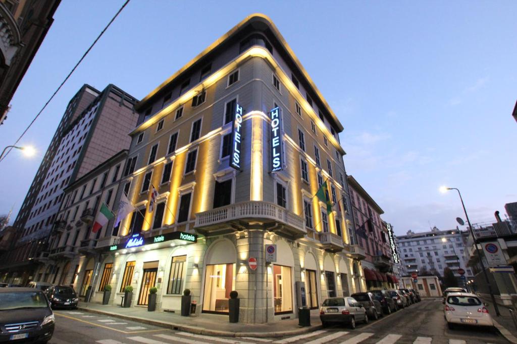 un edificio su una strada con auto parcheggiate di fronte di Mokinba Hotels Baviera a Milano