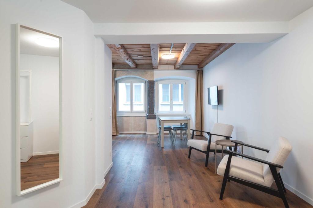 a room with a table and chairs and a mirror at HITrental Eisengasse Apartments in Lucerne