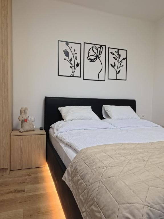 a bedroom with four pictures hanging above a bed at Studio Ariel in Veľký Meder