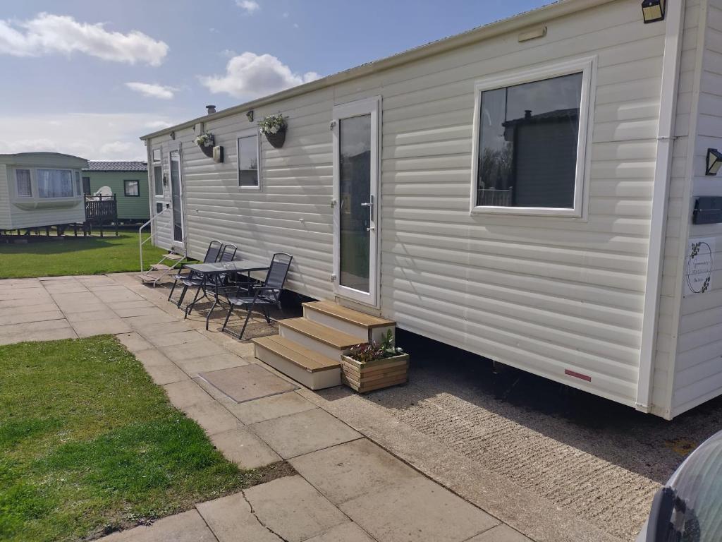 a white trailer with a patio and a table at 16 farmfield in Skipsea