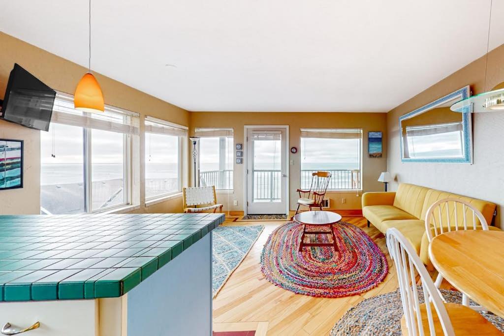 a living room with a couch and a table at Oceanfront Nye Beach condo with gorgeous corner view & beach access in Newport