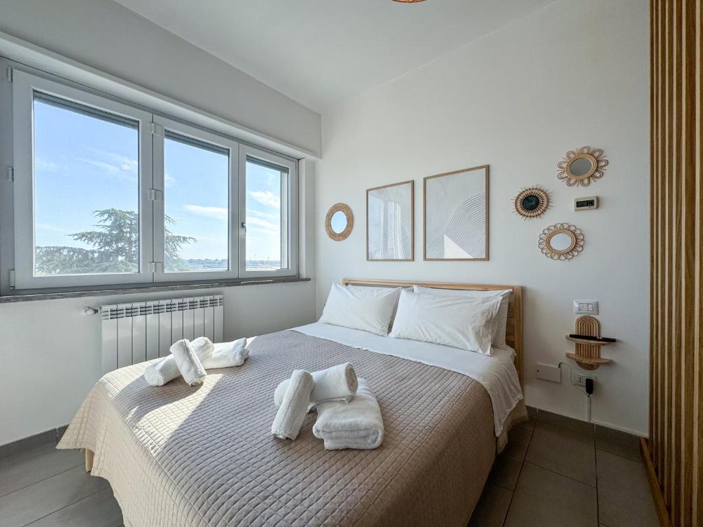ein Schlafzimmer mit einem Bett, auf dem Handtücher liegen in der Unterkunft Fly & Chill Ciampino Airport in Ciampino