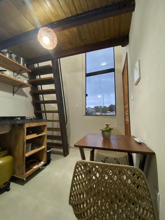 a dining room with a table and chairs and a window at Casaboa Apartamentos Passarela in Itacaré