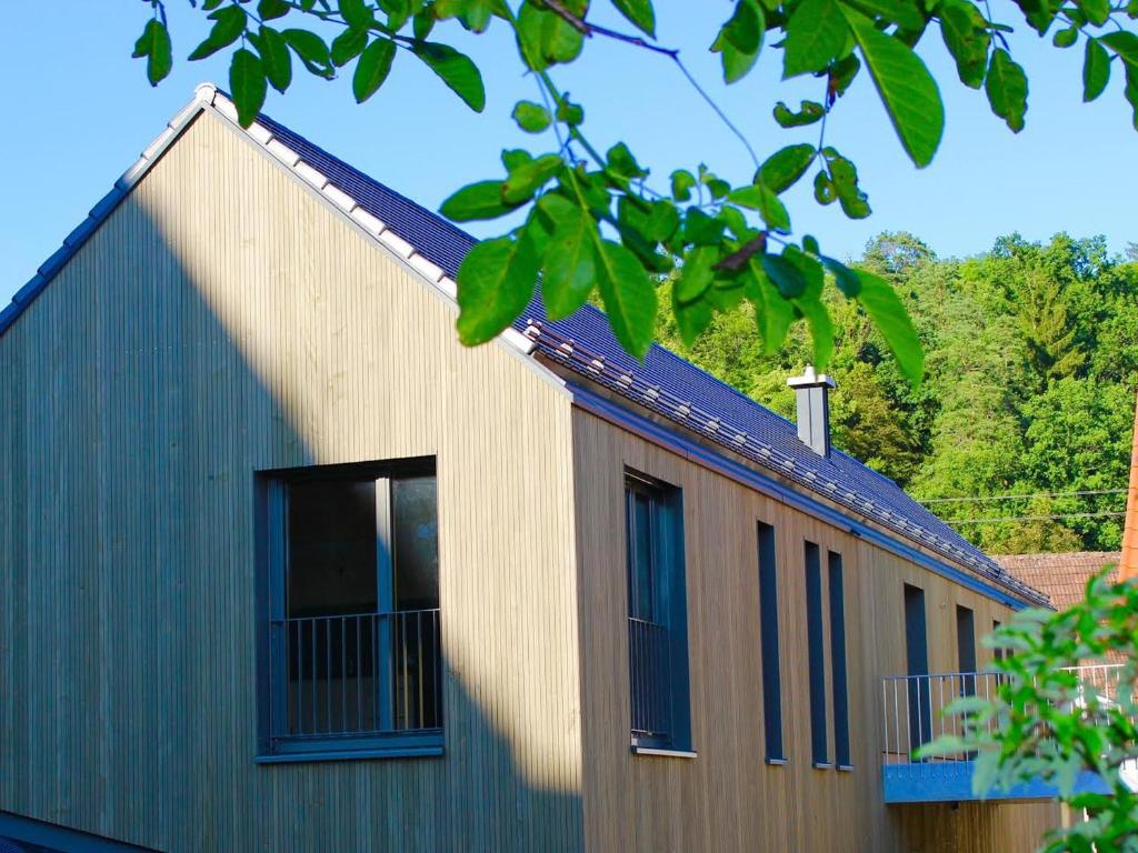 ein Gebäude mit blauen Fenstern an der Seite in der Unterkunft Dorfschmiede in Hüttlingen