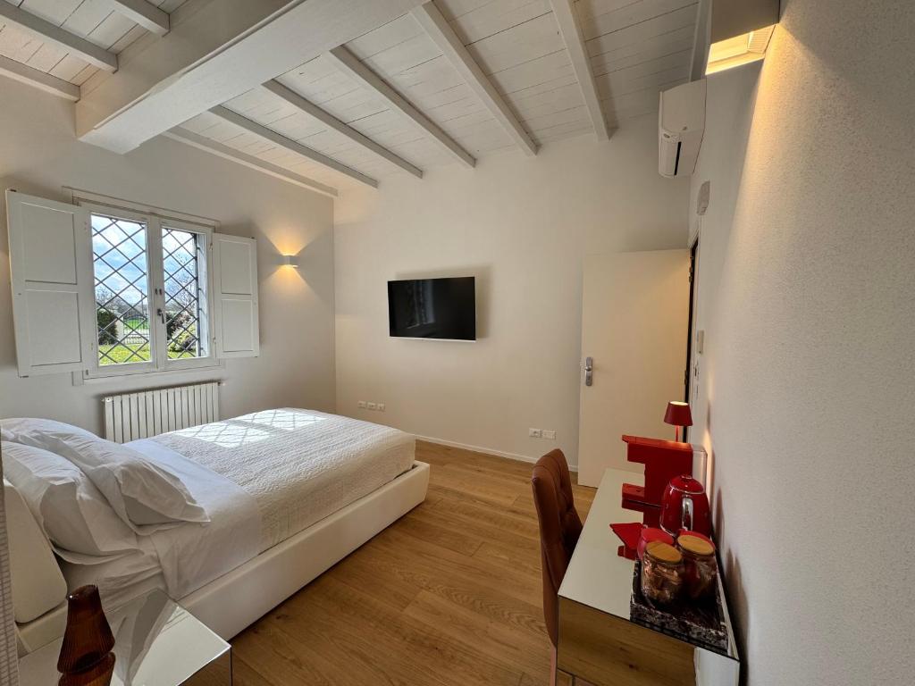 a bedroom with a bed and a table and a tv at Santa Caterina 1604 Suites in Anzola dell'Emilia