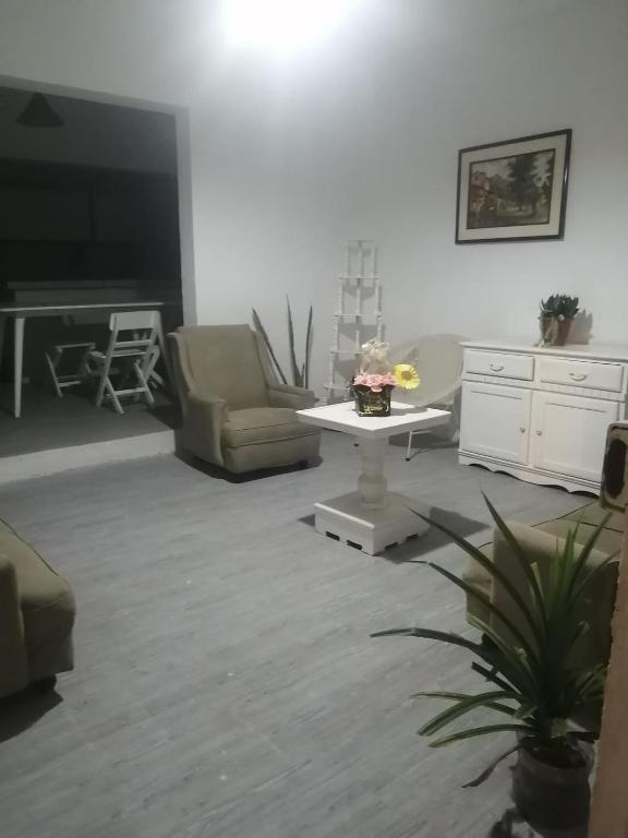 a living room with two chairs and a table and a television at Punta hermosa casa playa in Punta Hermosa