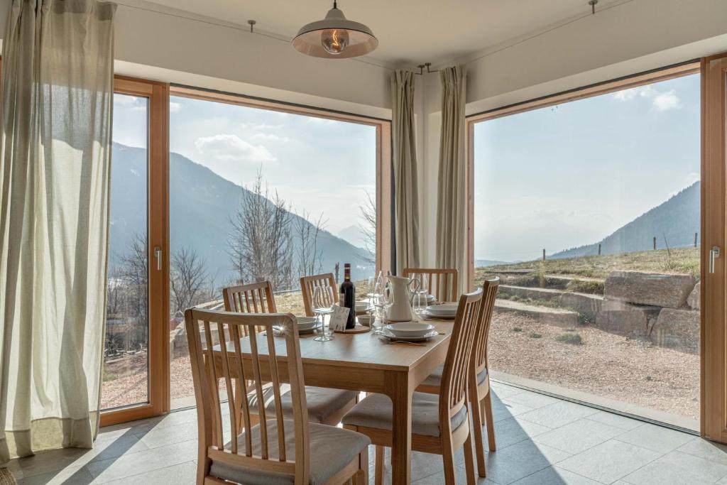 a dining room with a table and chairs and a large window at Nest Family, Bedollo Ospitar in Bedollo