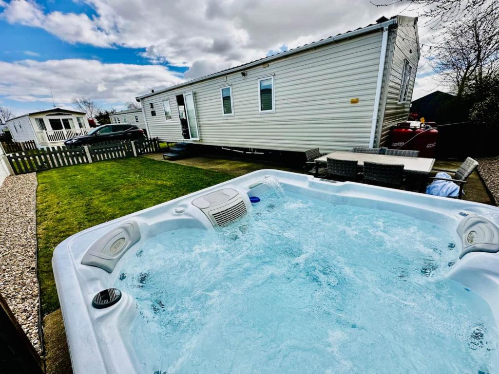a hot tub in a yard next to a house at 52 Sherringham Way in Patrington