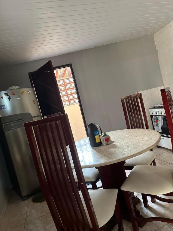 a kitchen with a table and chairs and a refrigerator at A queridinha do Orange in Itamaracá