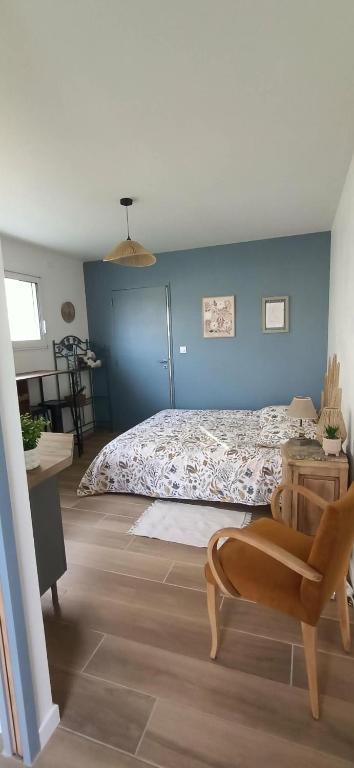 a bedroom with a bed and a blue wall at Studio85 in La Gaubretière