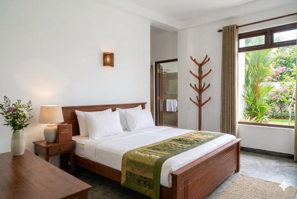 a bedroom with a large bed and a window at The Lark Resort ,induruwa in Induruwa