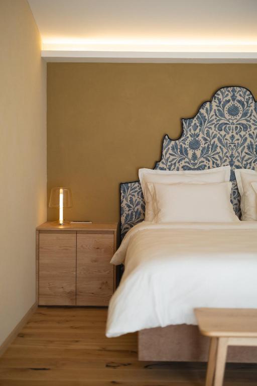 a bedroom with a bed with a blue and white headboard at Josefina unique hotel, adult only in Kozina