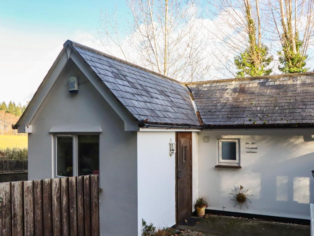 a small white house with a wooden fence at The Old Telephone Exchange in Exeter