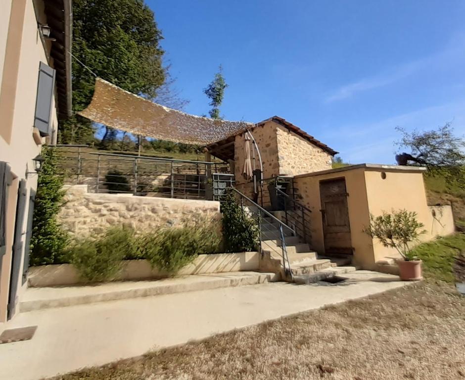 a house with a fence and stairs in front of it at Maison de campagne in La Fouillade