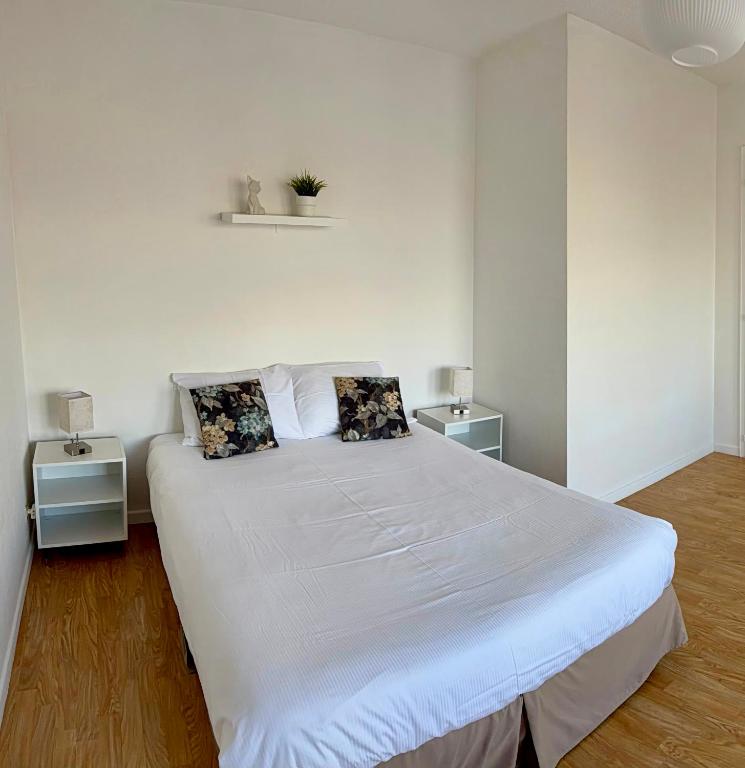 a bedroom with a large white bed with two tables at Studio cosy à Molsheim Calme, centre-ville et accès Strasbourg in Molsheim
