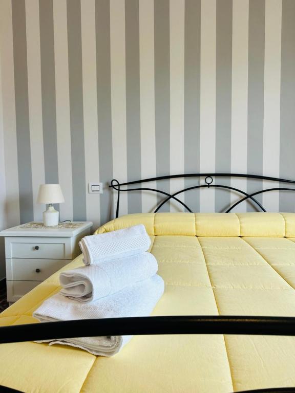 a yellow bed with towels on top of it at MR1 House Gallipoli in Gallipoli