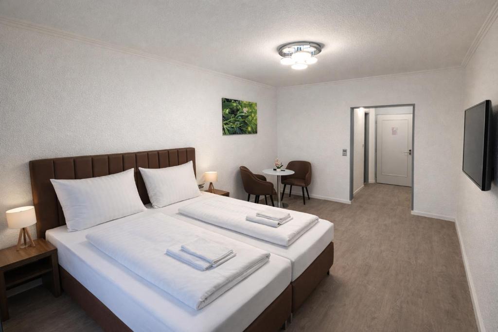 a hotel room with a large bed and a table at Hotel Hansahof Bremen in Bremen