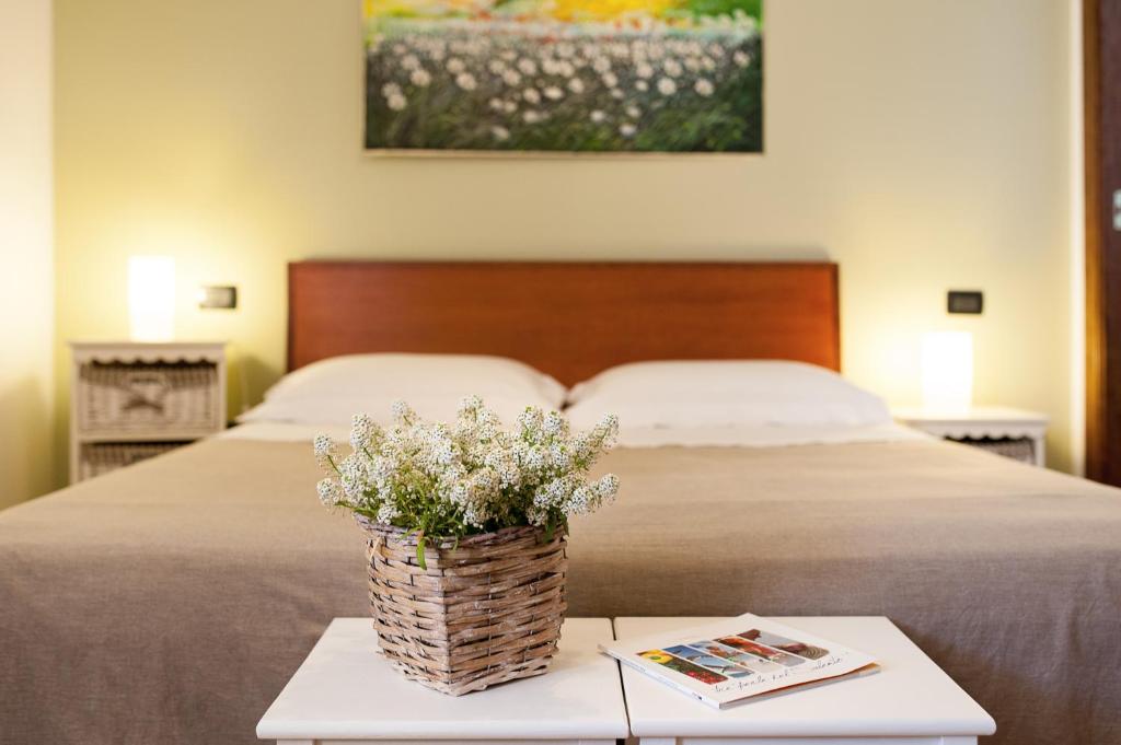 a table with a basket of flowers on a bed at Antico Camino B&B in Muro Leccese