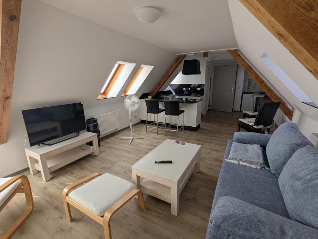 a living room with a blue couch and a table at Ferienwohnung in Schkölen in Schkölen
