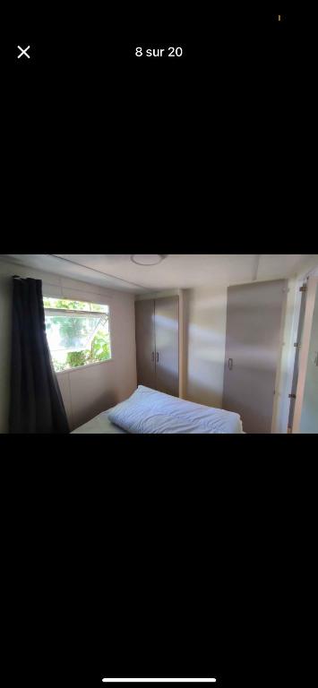 a small bedroom with a bed and a window at Nature in Saint-Pierre-dʼOléron